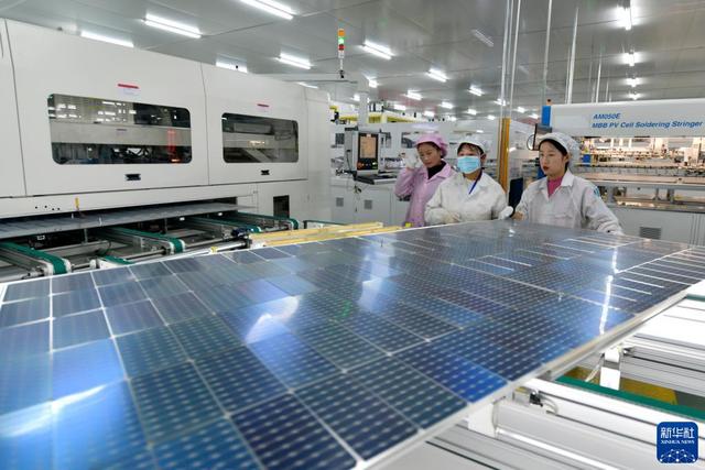 工人在一家光伏组件生产企业的车间里作业。 资料图：新华社