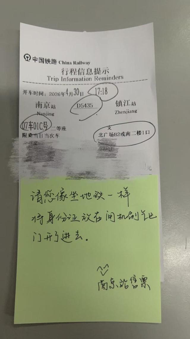 南京站售票窗口工作人员手写便签提示老人旅客乘车流程。唐荔彤 摄