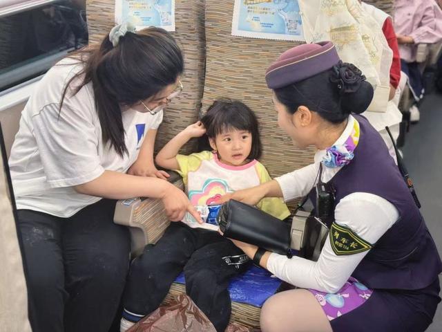 杭州客运段列车长耐心解答小旅客提问。张力 摄