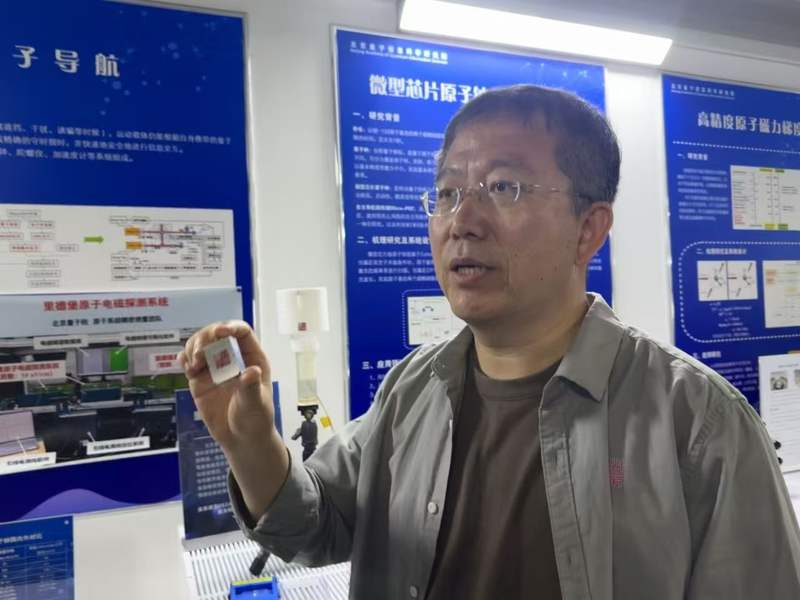 杨仁福向记者介绍微型原子钟。新京报记者 耿子叶 摄