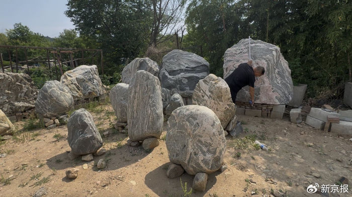 ▲5月13日，泰山附近一户“石农”正在测量一块泰山石的尺寸。新京报记者 齐少乾 摄