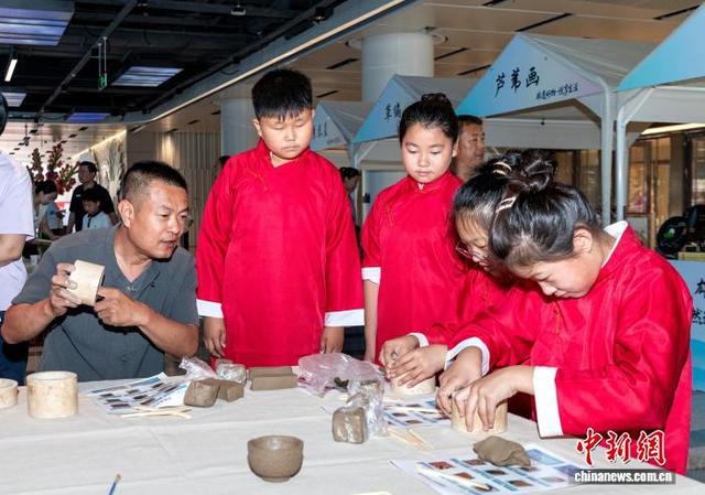 图为活动现场小朋友们体验黑陶制作。中新社记者 韩冰 摄