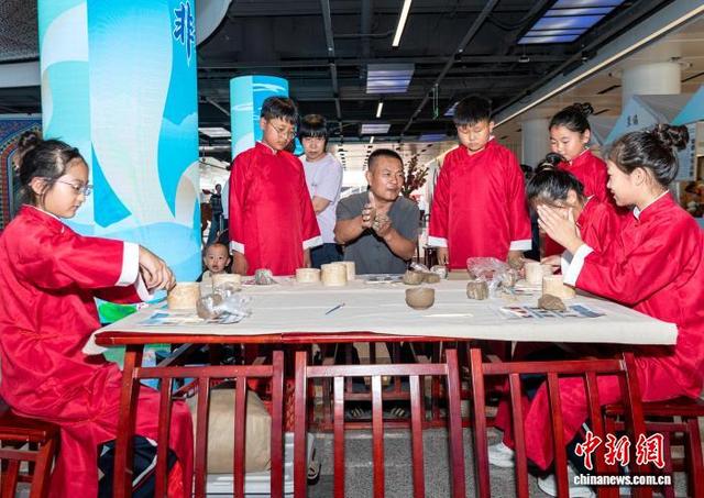 图为活动现场小朋友们体验黑陶制作。中新社记者 韩冰 摄