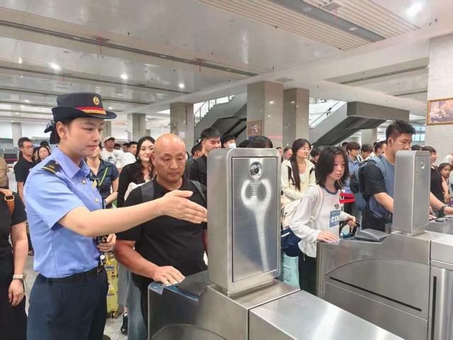 阜阳西站工作人员组织旅客有序检票进站。 谷晨 摄
