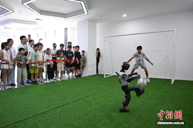 图为两岸青少年观看足球机器人展示，并与机器人互动。中新社记者 何蓬磊 摄