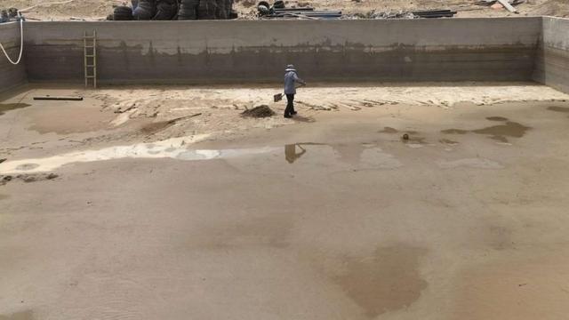 基地旁的蓄水池，工作人员正在进行清理工作