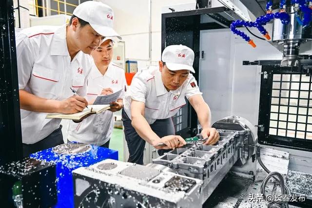 2023年6月8日，杨永修（右）在中国一汽研发总院检查试制零部件的精度。新华社记者 许畅 摄