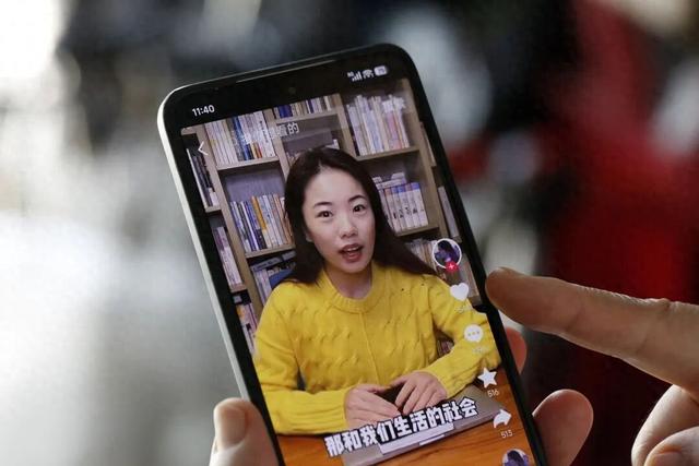 一名文学爱好者通过手机浏览作家蒋方舟相关的短视频 图源：视觉中国