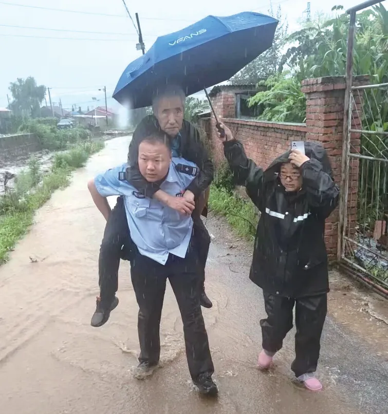 抚顺“7·13”特大暴雨中，东洲公安分局章党镇派出所民警转移被困群众。图源：今抚顺