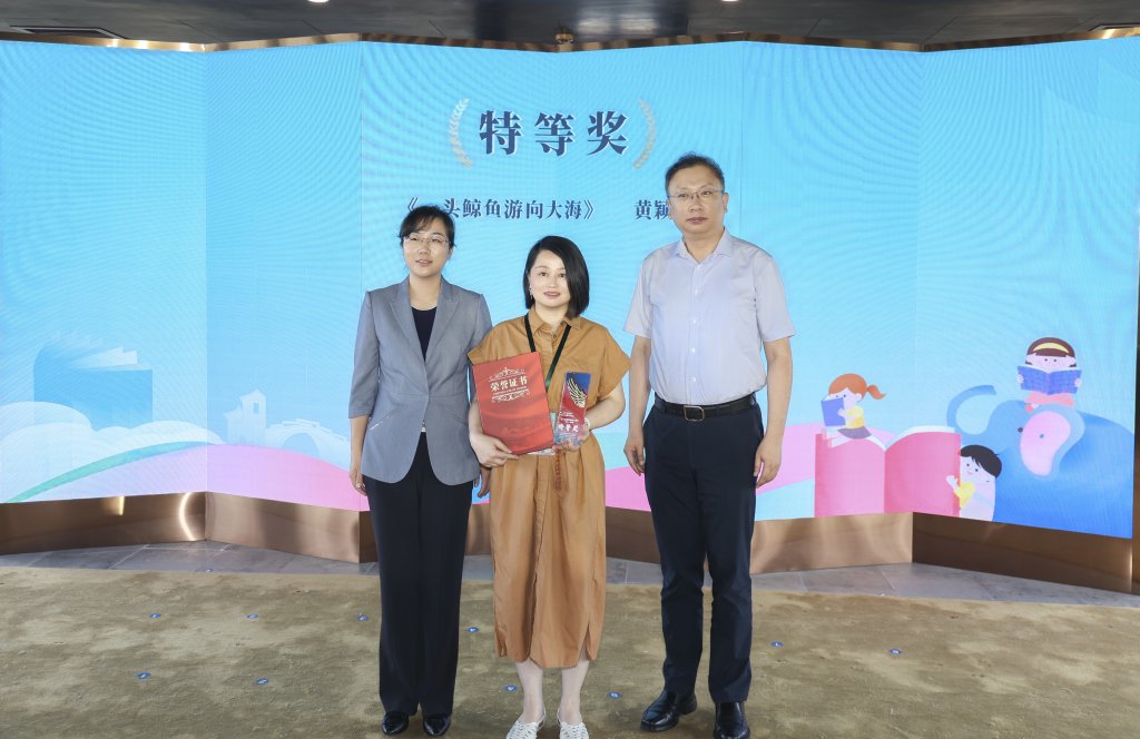 上海世纪出版集团副总裁秦志华（右一）、昆山市委宣传部副部长朱文琦（左一）为特等奖获奖者黄颖曌颁奖。