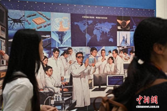 参观者经过之江实验室展览中心内的科学家画像。 中新社记者 满会乔 摄