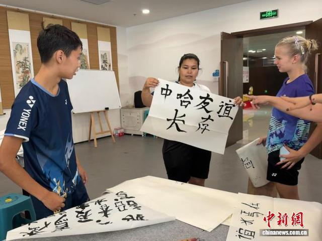 图为哈萨克斯坦青少年展示自己的书法作品，上面写着“中哈友谊长存”。张家伟 摄