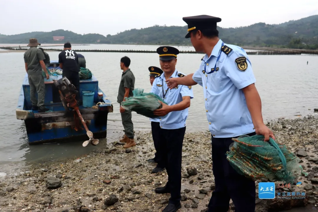 执法人员在铁炉港红树林自然保护区收缴禁用渔具地笼。