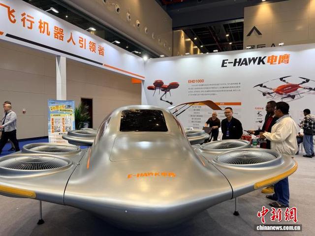 10月10日，2026武汉人工智能与机器人博览会在武汉开幕。图为外籍采购商围观电鹰飞车展品。 中新社记者 马芙蓉 摄