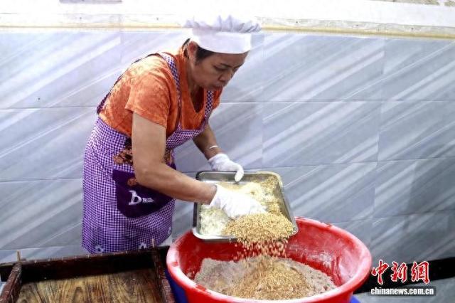 图为钟惠群在制作里高糯香米饼。牙春柳 摄