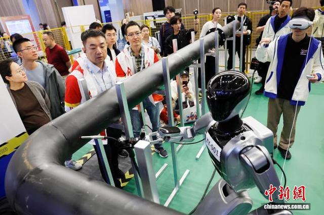 图为在焊接赛事项目区域，选手对机器人进行调整。中新社记者 殷立勤 摄