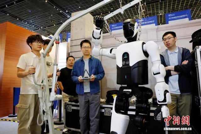 图为工作人员对即将参加比赛的机器人进行调整。中新社记者 殷立勤 摄