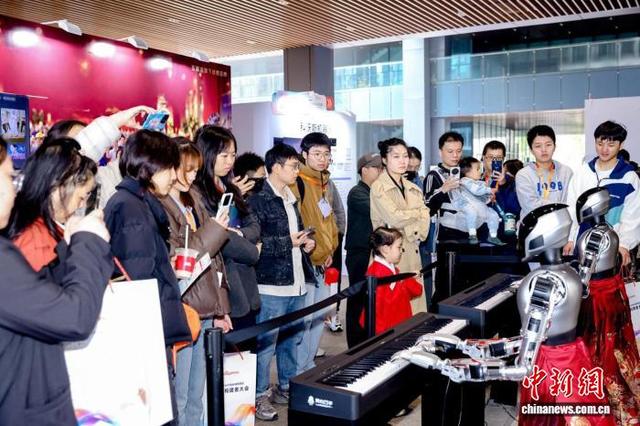 民众在活动现场被机器人吸引。湖南湘江新区供图