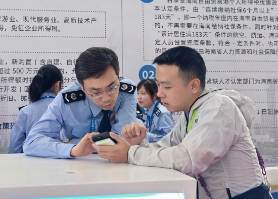 图为周渊在消博会税费服务中心税务人员解答现场观展游客涉税疑问。