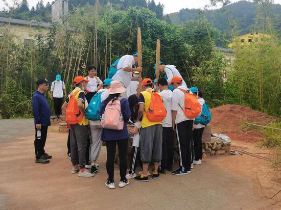 近年来掀起土楼研学热,图为研学队伍体验客家土楼建造技艺。