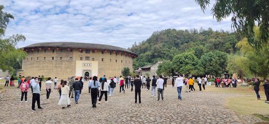 11月15日周末,永定景区“土楼王子”振成楼前的游客络绎不绝。