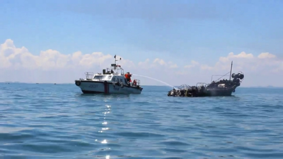 海警人员对失火渔船重点部位实施喷淋，彻底排除复燃风险