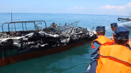 海警人员对失火渔船重点部位实施喷淋，彻底排除复燃风险