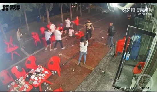 网传视频里，几名男子将白衣女子拖到室外殴打。 图片来源：视频截屏