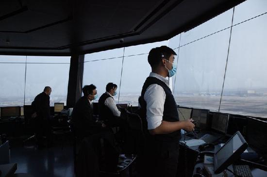 图:首都机场塔台管制员指挥航班雪中起降 摄影:徐小桩
