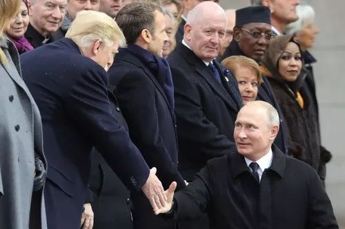 2018年11月11日，在法国首都巴黎，前来参加第一次世界大战结束一百周年纪念仪式的俄罗斯总统普京（右下）与美国总统特朗普握手。新华社/法新