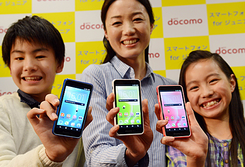  在日本首都东京NTT DOCOMO公司的媒体预览会上，模特展示新款青少年智能手机“SH-05E”。（新华社）