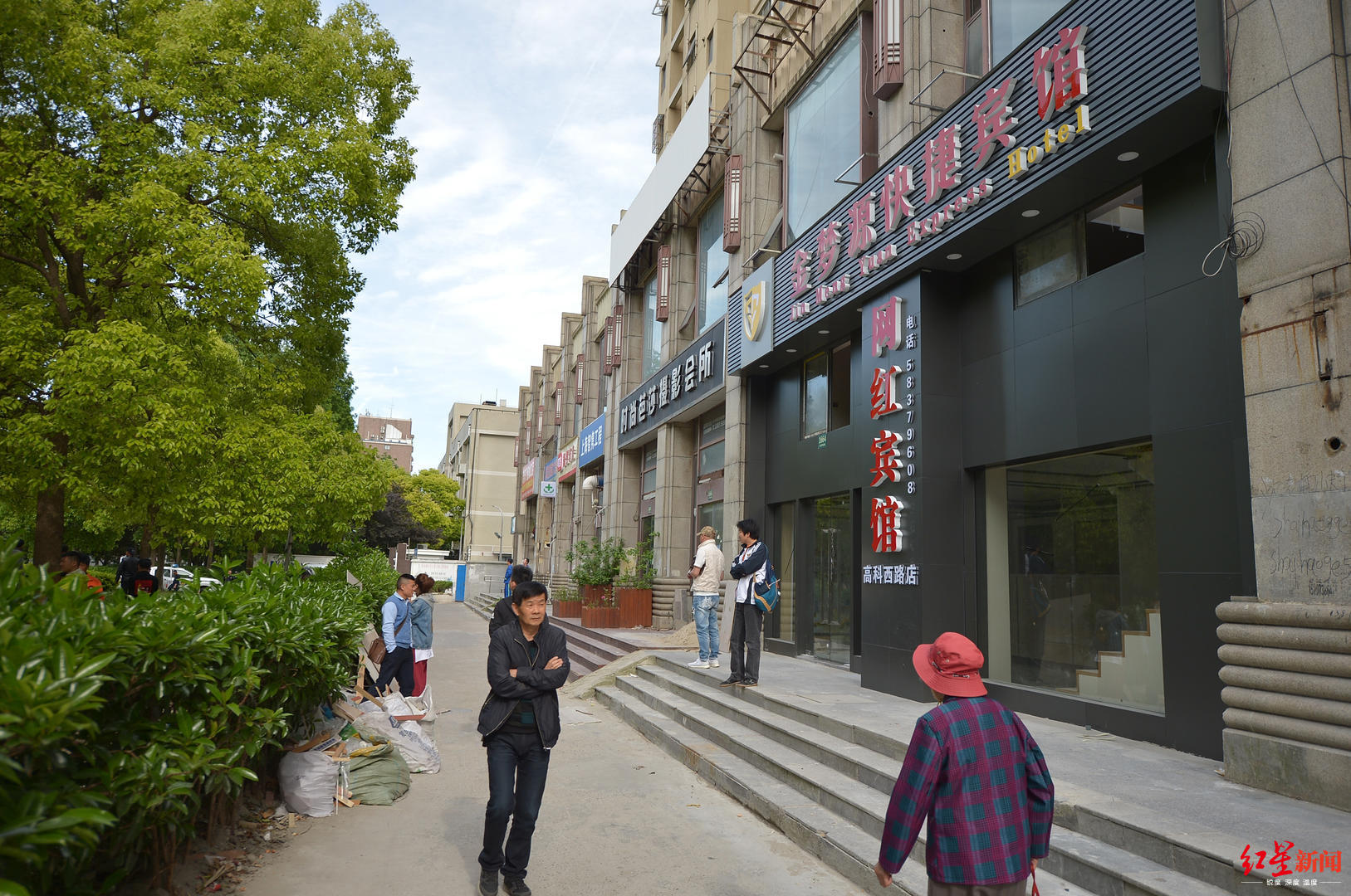 　▲2019年5月7日，上海市杨高南路地铁站出口，沈巍栖身的宾馆老板特意把招牌改为网红宾馆。