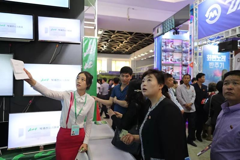 5月20日，在第22届平壤春季国际商品展览会现场，朝鲜民众在一家销售电视的展台前选购产品。新华社记者程大雨摄