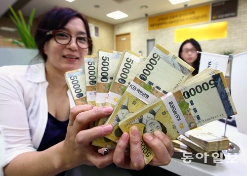 一位韩国银行职员展示面额5万元的纸币（韩国《东亚日报》）