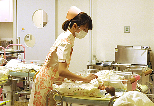 资料图片：在日本熊本县熊本市慈惠医院，医护人员在照料婴儿。（新华社）
