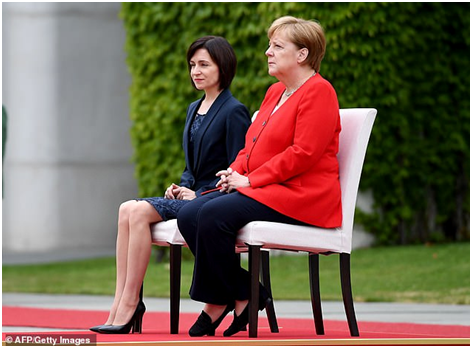 （当两国国歌奏响时，默克尔与摩尔多瓦总理桑杜坐在了椅子上。图源：法新社）