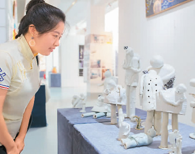 　　6月20日，“新时代·新活力——第六届内蒙古创意设计展”在位于呼和浩特市的内蒙古展览馆举行，共展出18所院校和协会的1200多组作品。图为观众在欣赏创意设计作品《低头族》。丁根厚摄（人民视觉）