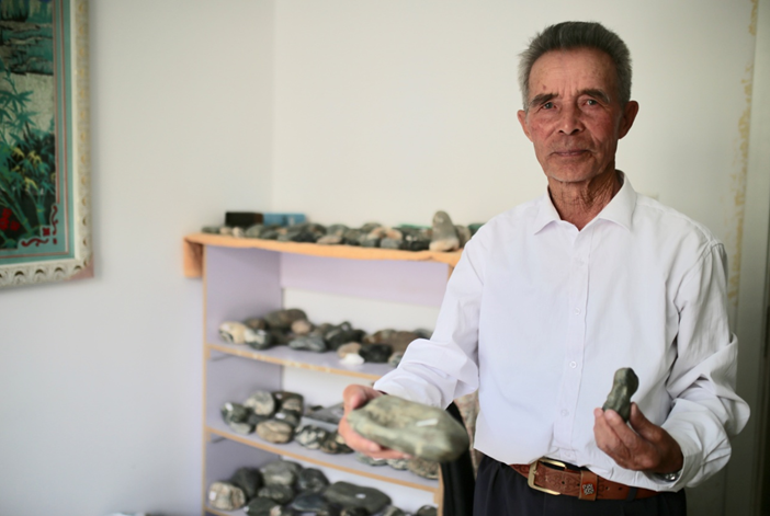 80歲的老礦工艾達(dá)爾汗&middot;恰勒哈爾拜給記者看他收集的奇形怪狀的石塊兒。范凌志攝