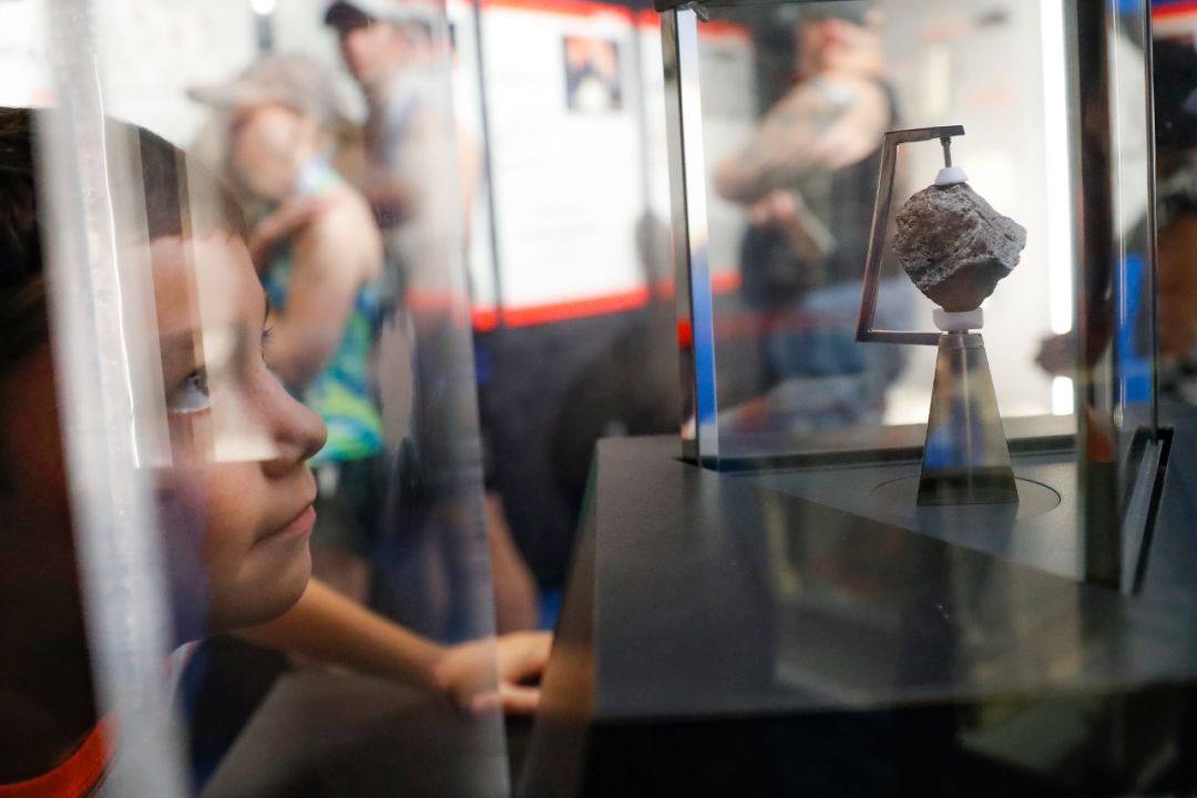 　7月20日，在美国俄亥俄州的沃帕科内塔，一名男孩在“尼尔·阿姆斯特朗航空航天博物馆”内参观一块月球岩石样本。新华社/美联