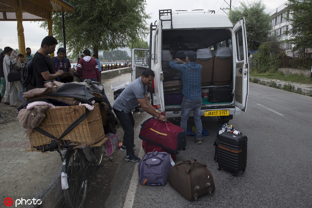准备离开该地区的游客正在搬运行李。（IC Photos）