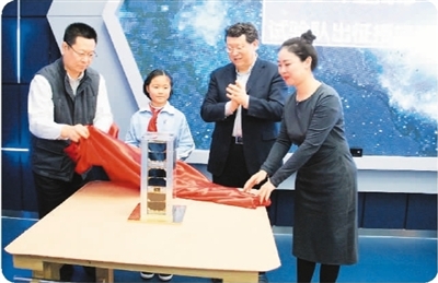 少年星一号是中国首颗教育共享卫星，由航天民企九天微星在吸收广大青少年创意基础上研制。图为少年星一号揭幕仪式。 新华社发