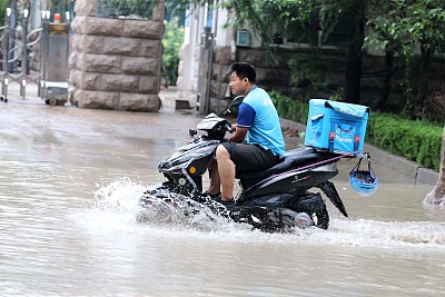 受“利奇马”影响山东潍坊普降大雨 市民在道路积水中前行