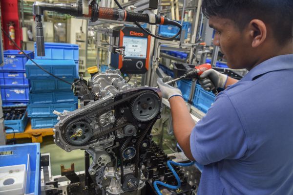 资料图片：印度孟买以东约200公里的兰贾冈，一名工人正在FCA印度汽车制造厂组装发动机。（法新社）