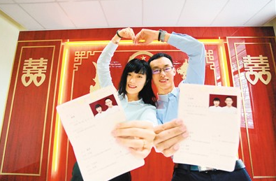 8月7日，在江苏省扬州市广陵区民政局婚姻登记处，一对新人展示刚领取的结婚证。孟德龙摄（人民视觉）