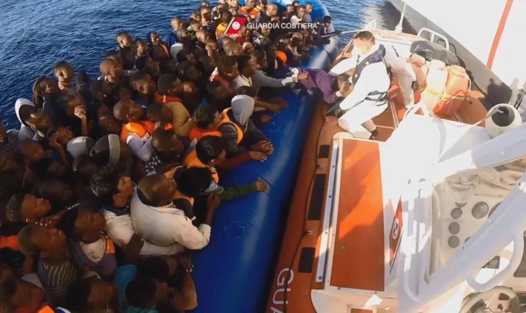 2016年11月7日，在地中海上，被救起的偷渡难民准备登上意大利海岸警卫队的救援船。新华社/欧新中文