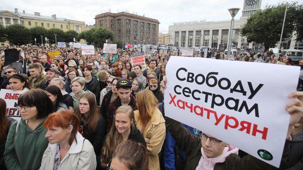 圣彼得堡团结的一场抗议活动中，人们手举“让卡查图尔扬姐妹获得自由”的横幅。图据BBC新闻