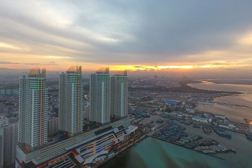 这是在印度尼西亚首都雅加达拍摄的夕阳下的红溪湾港口。新华社记者杜宇摄