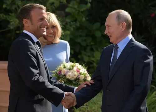 8月19日，在法国南部布雷冈松堡，法国总统马克龙（左）和俄罗斯总统普京握手致意。新华社/路透