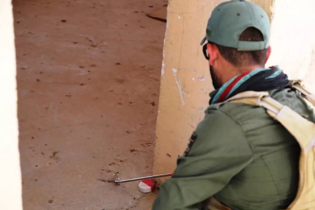 图为排雷队员库杜尔进入清理区域前查看盲区。新华社记者张淼摄