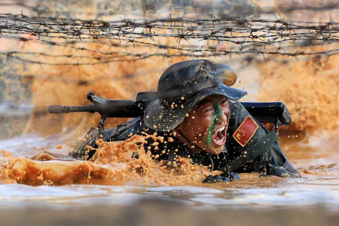 资料图片:驻澳门部队特种作战连战士在训练中通过泥潭.
